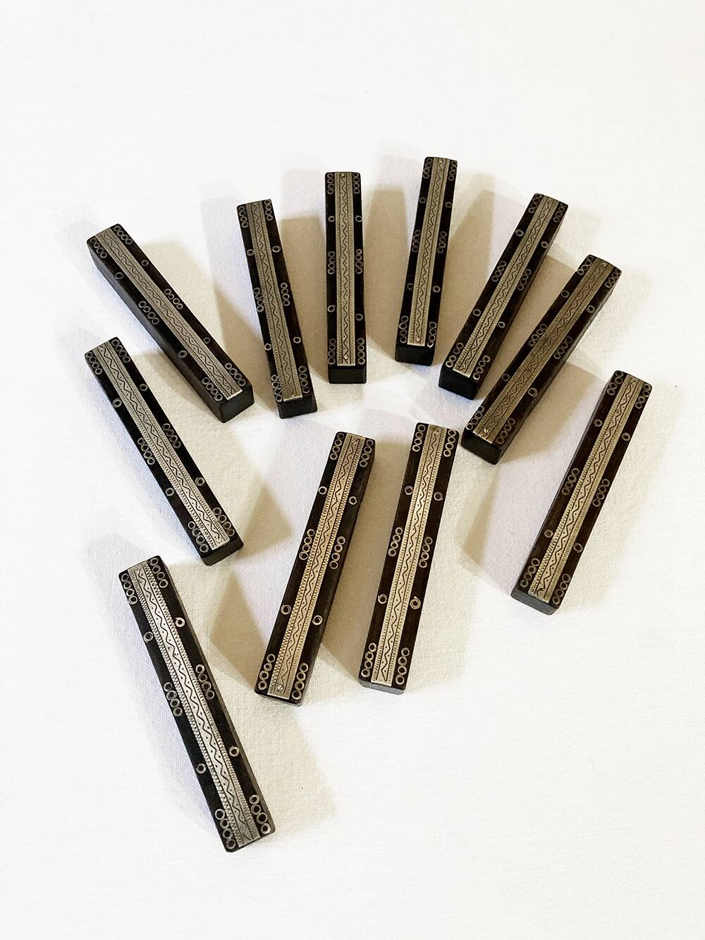 Set of 11 ebony wood knife rests with brass inlay