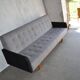 Mid-Century 1960s canapé in grey fabric with black armrests, natural wood base.
