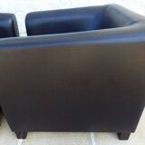 2 club armchairs with a chocolate faux leather seat and backrest and wooden legs.