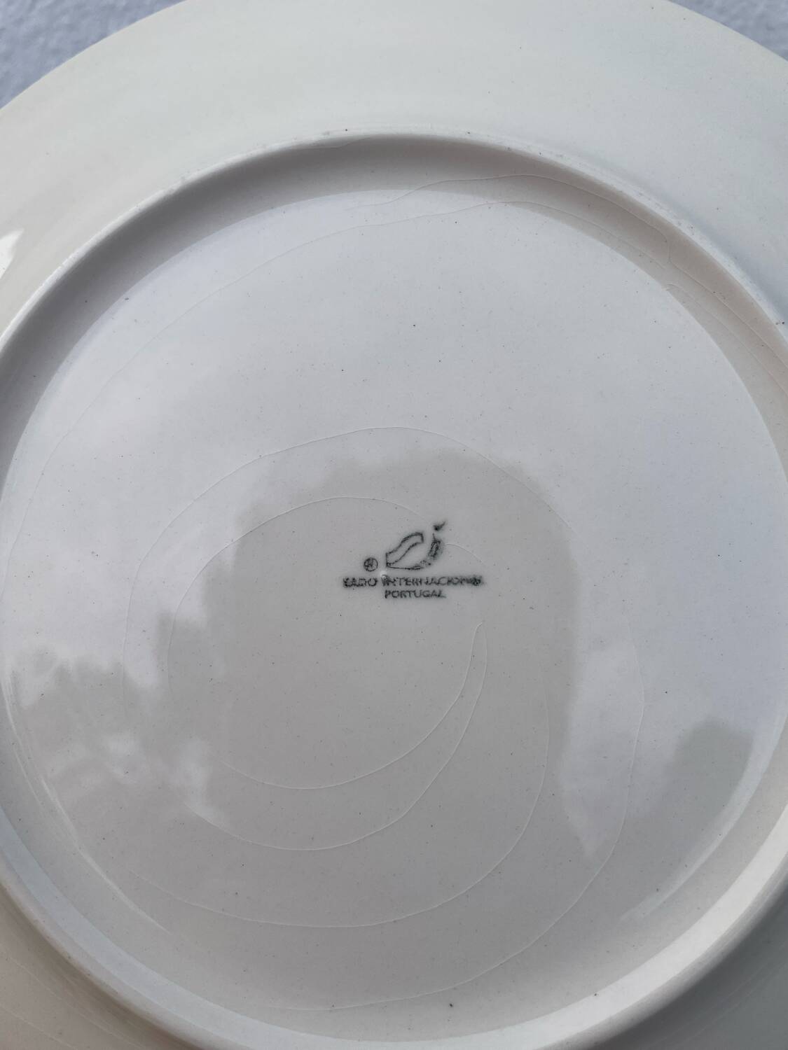 Set of 10 ceramic plates with green foliage decoration.