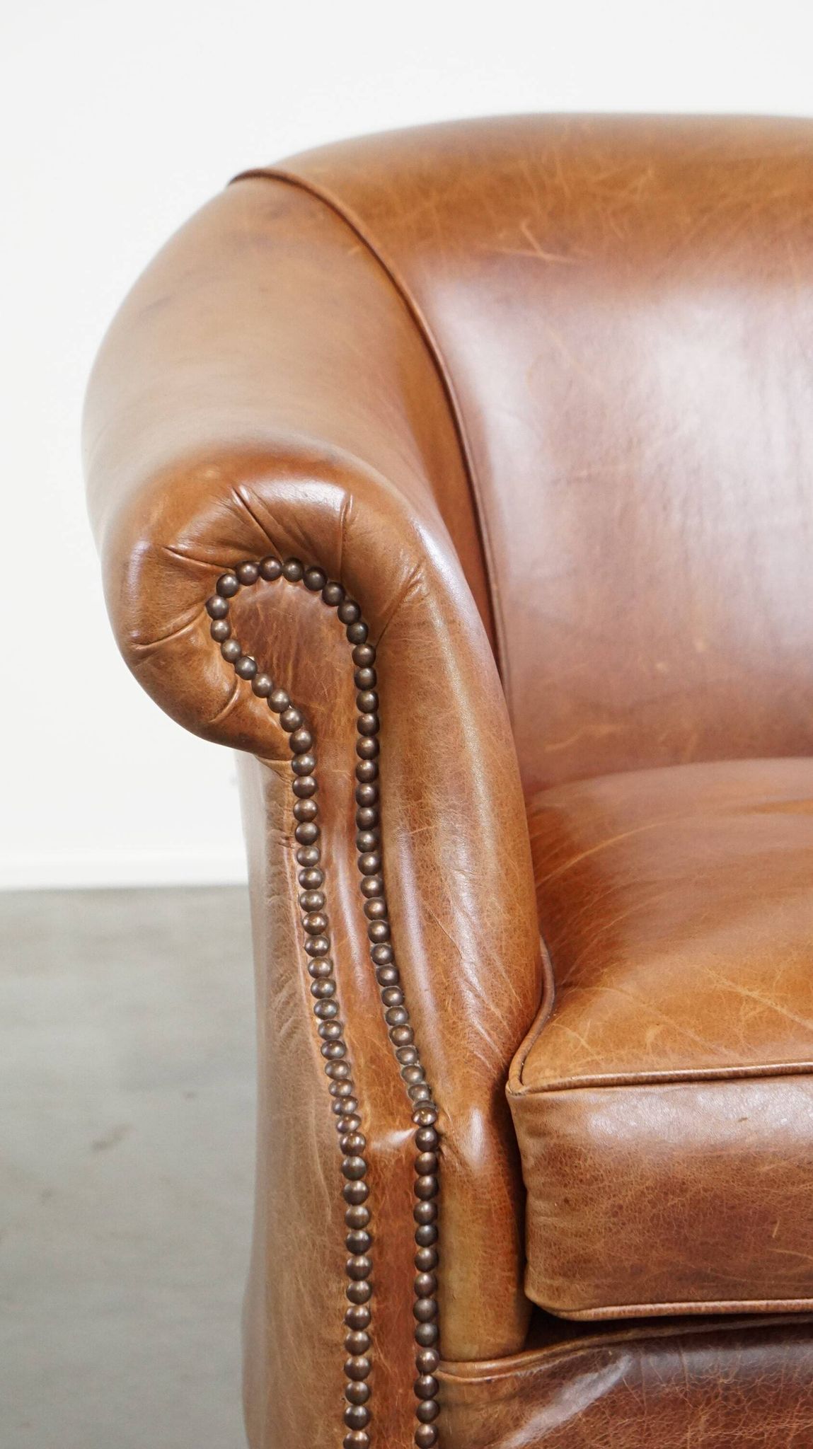 Very comfortable, elegant leather club armchair with a removable seat cushion and timeless design
