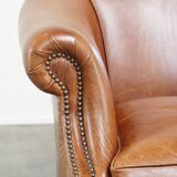 Very comfortable, elegant leather club armchair with a removable seat cushion and timeless design