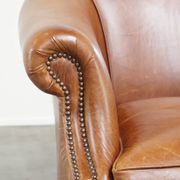 Very comfortable, elegant leather club armchair with a removable seat cushion and timeless design