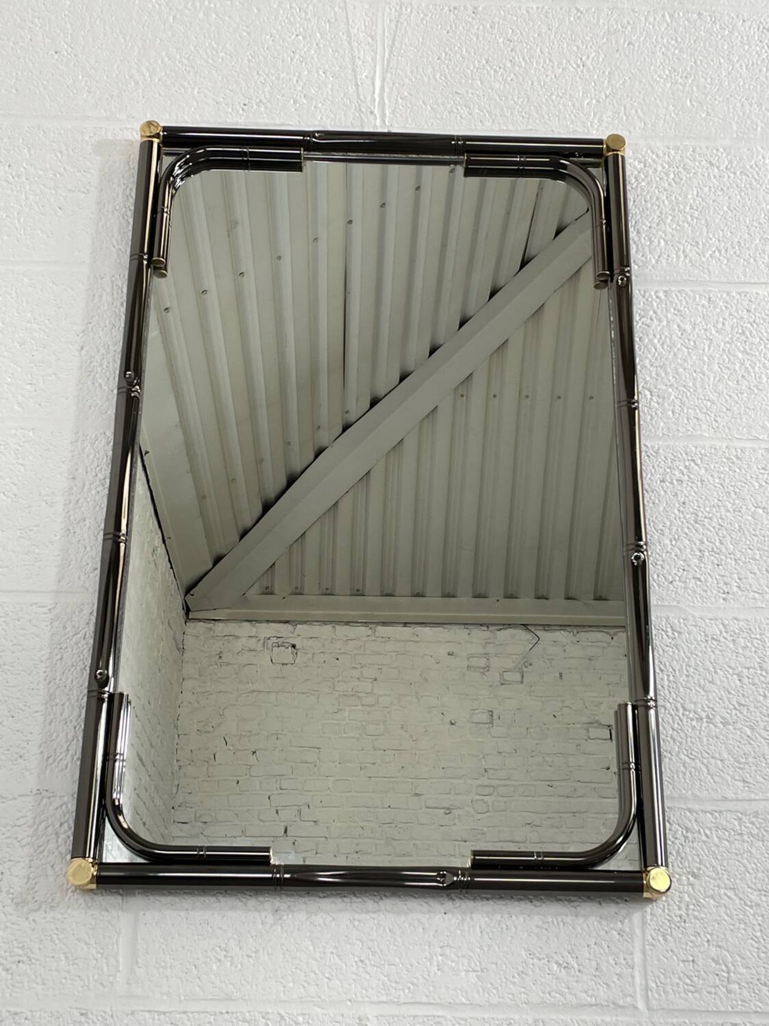 Mirror in black metal and brass with gunmetal finish