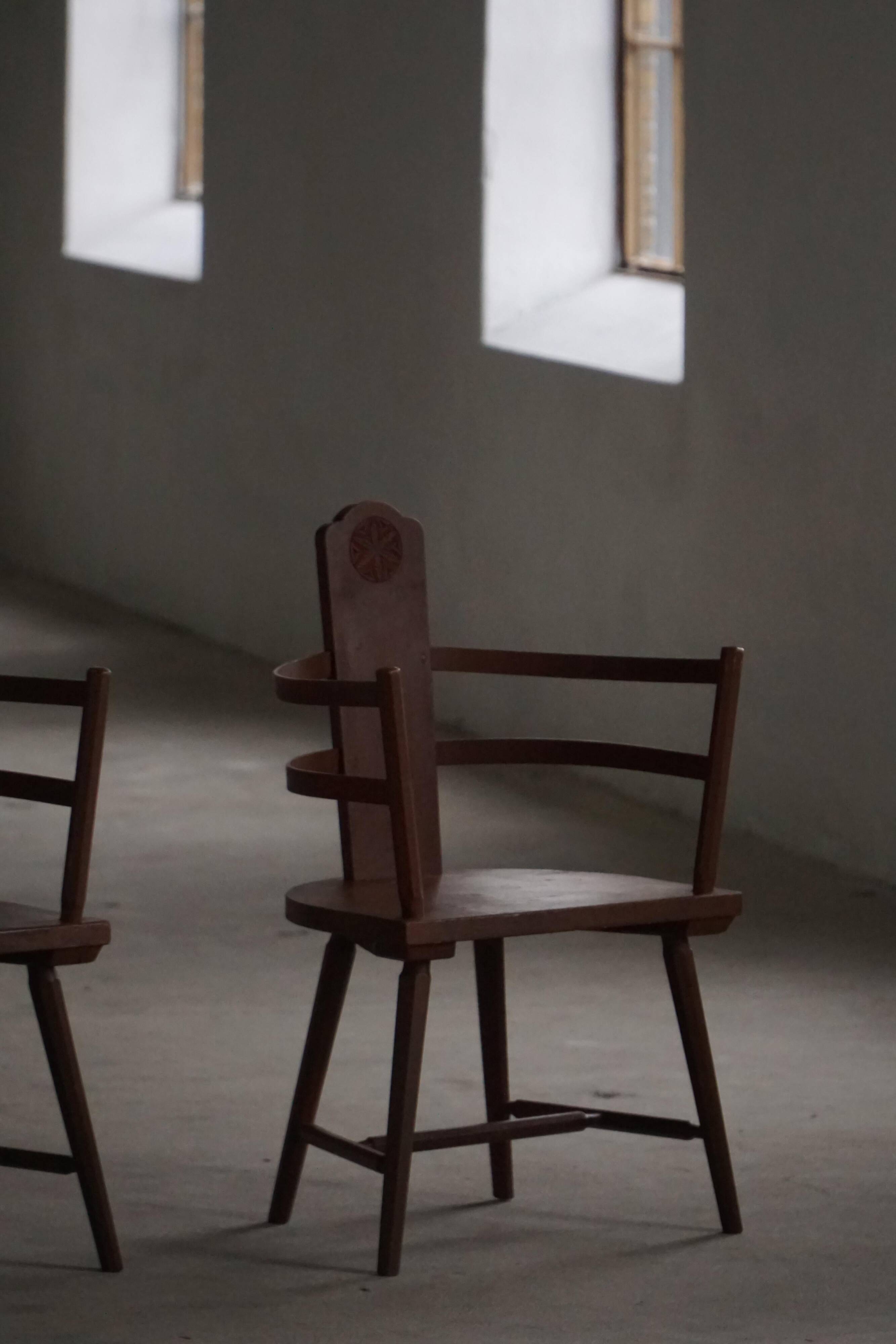 Pair of Scandinavian wooden armchairs with hand-carved folk motifs, 1920s.