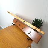 Vintage wall coat rack with black hooks and light wood
