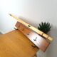 Vintage wall coat rack with black hooks and light wood