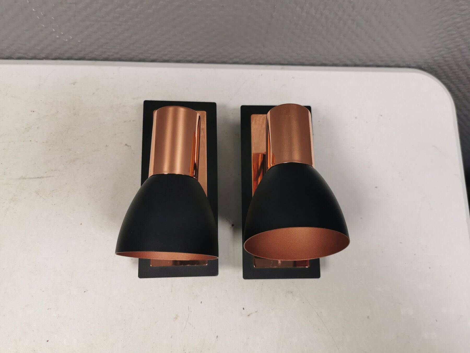 A pair of wall lamps from Eglo, in copper color and black.