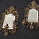 Pair of mirror wall sconces with brass candle holders.