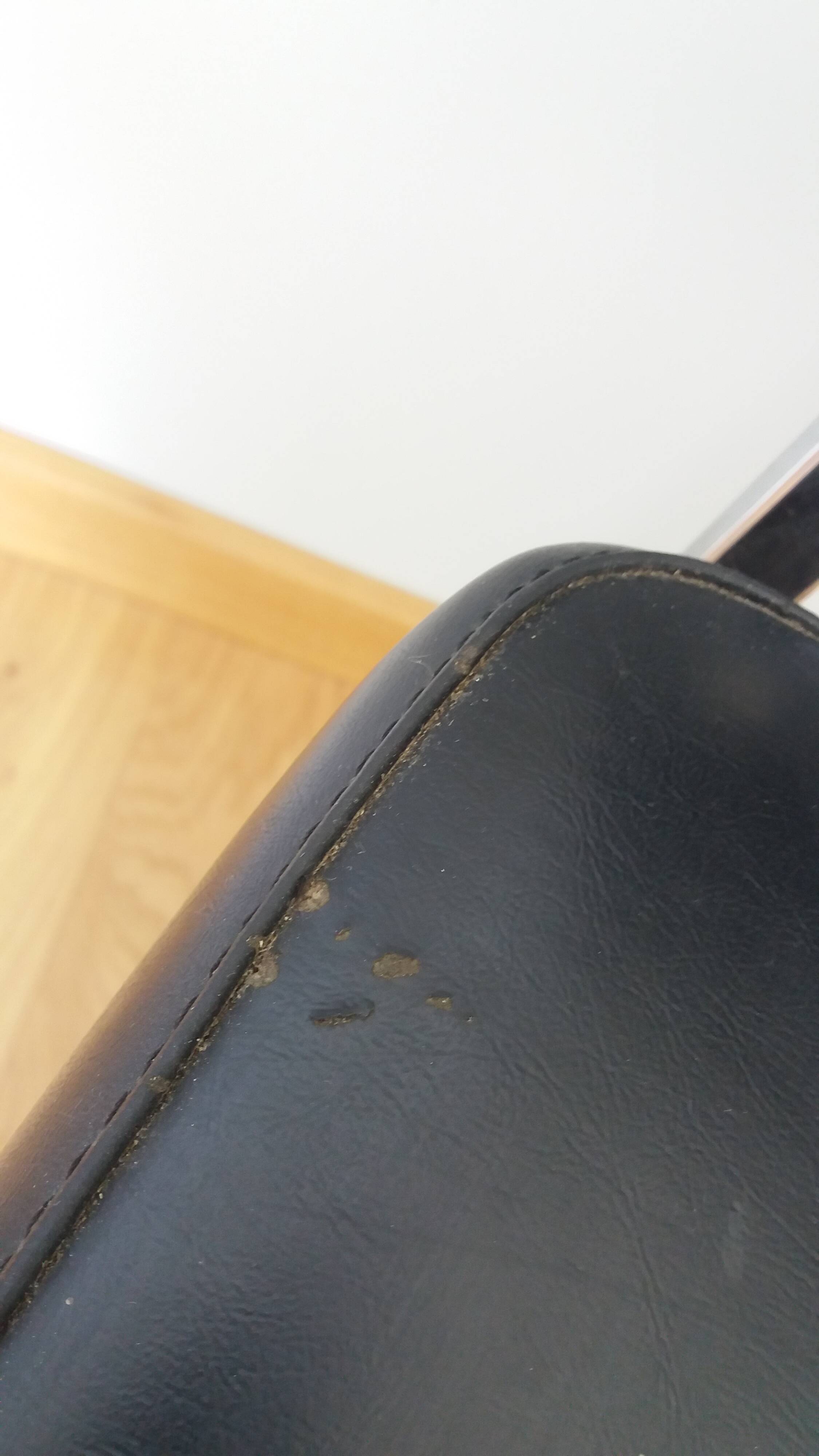 Chrome metal chairs and black faux leather upholstery in retro modernist style.