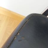 Chrome metal chairs and black faux leather upholstery in retro modernist style.