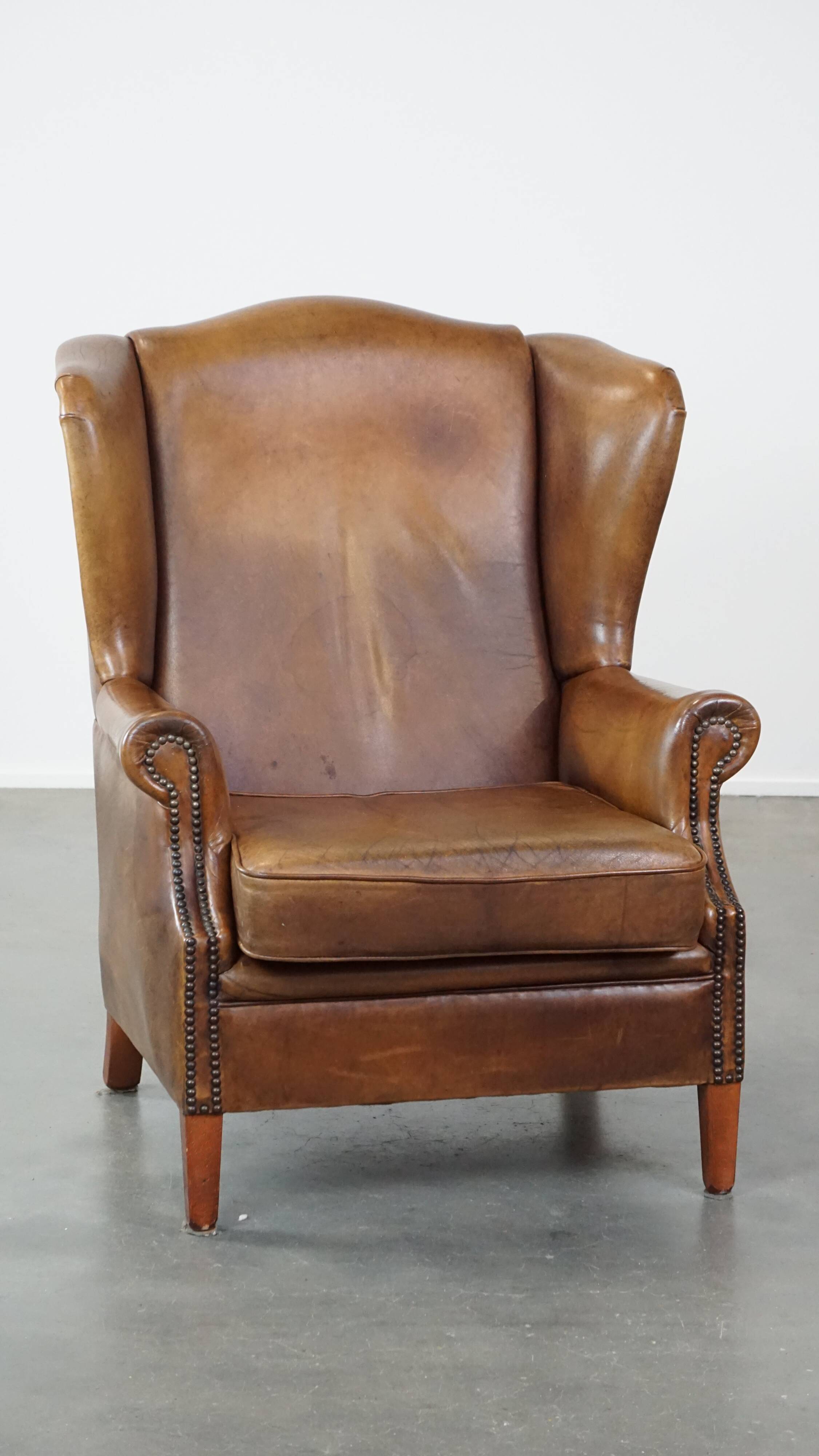 Charming sheep leather wingback armchair with a beautiful patina and excellent seating comfort