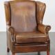 Charmant fauteuil à oreilles en cuir de mouton avec une belle patine et un excellent confort d'assise