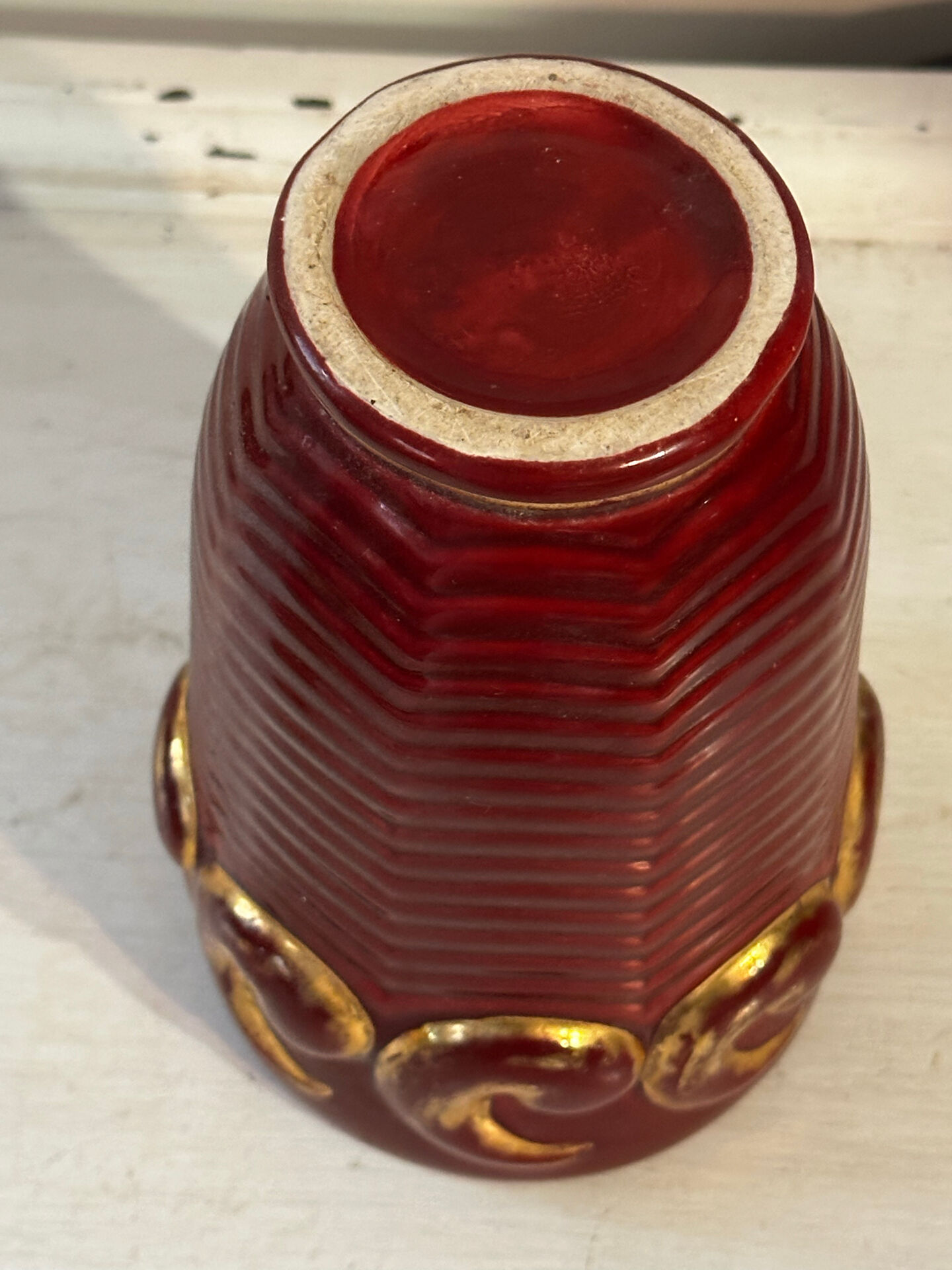 Mid-century relief vase in ruby red enhanced with gilding.