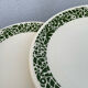 Set of 10 ceramic plates with green foliage decoration.