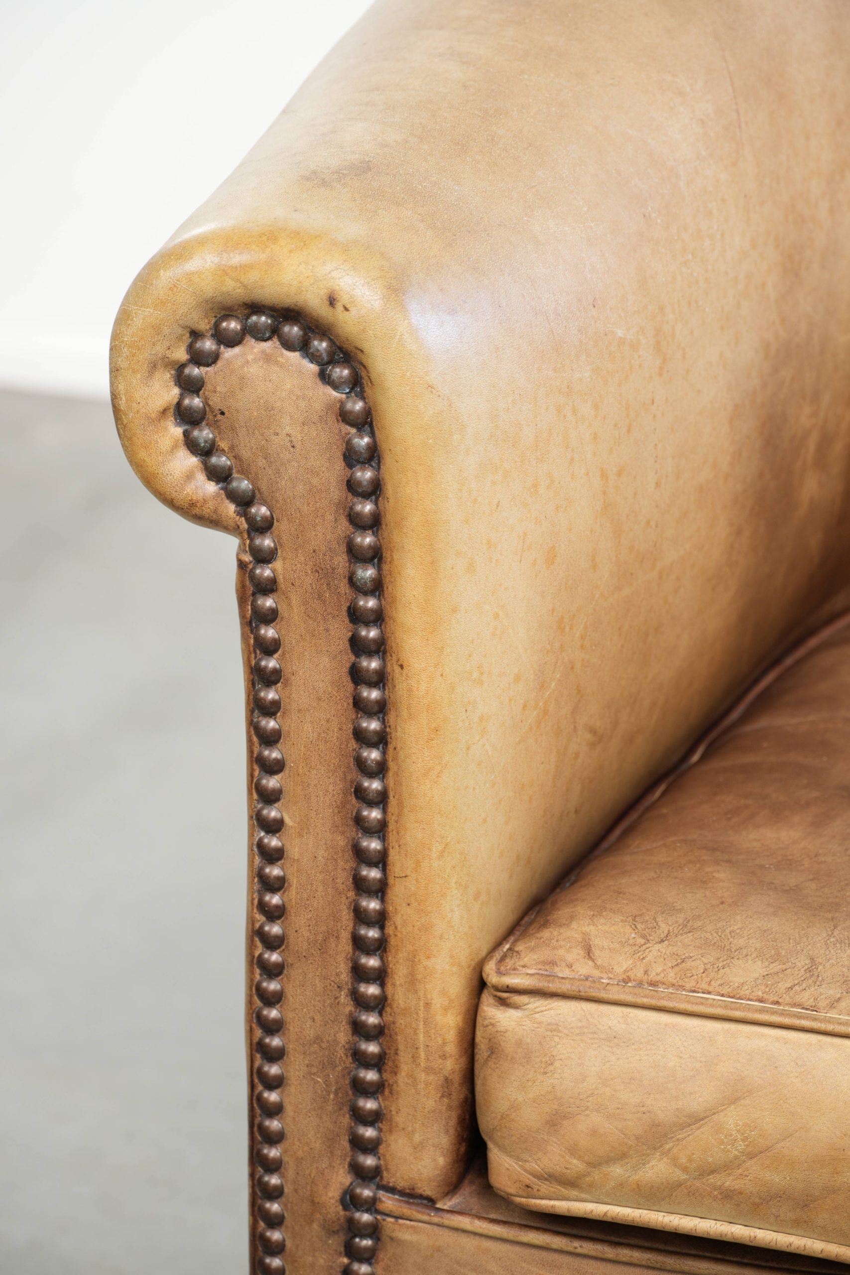Vintage cowhide club armchair in English style in a light colour scheme