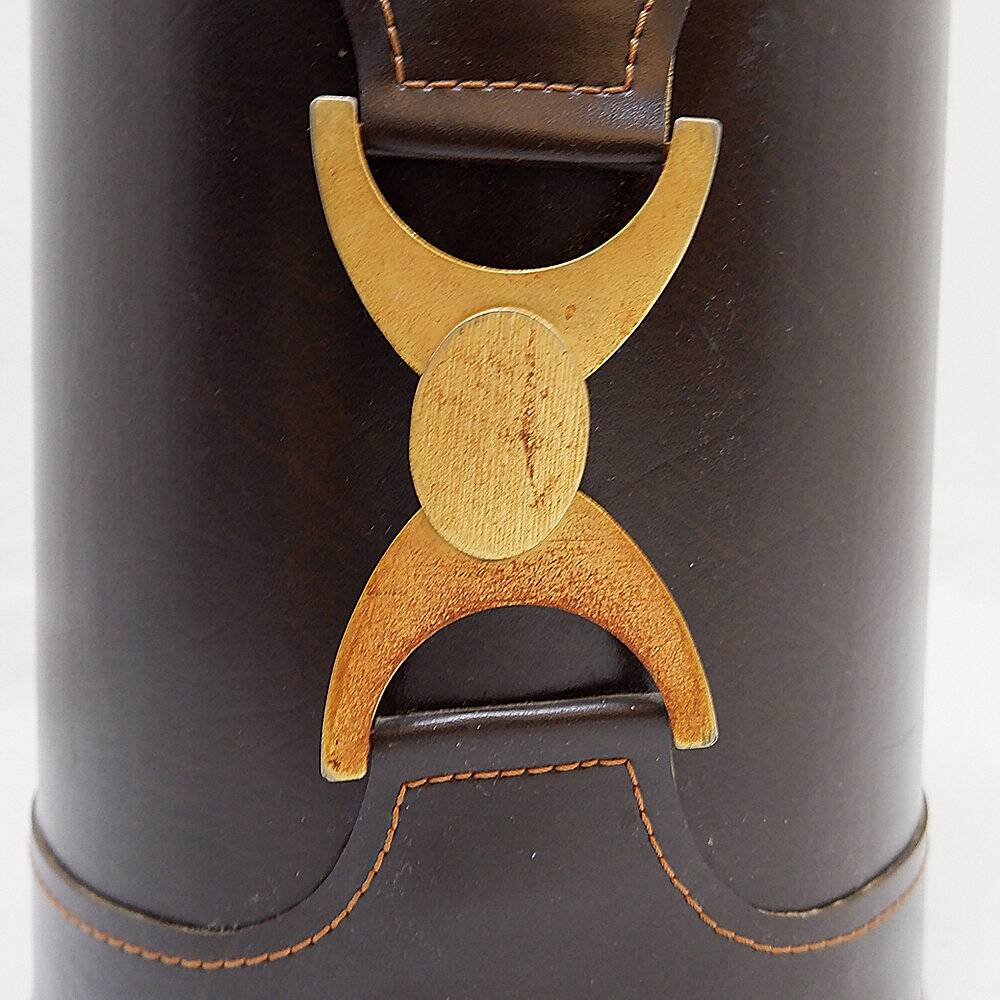 Brown leather wastepaper basket with decorative gold metal buckle.