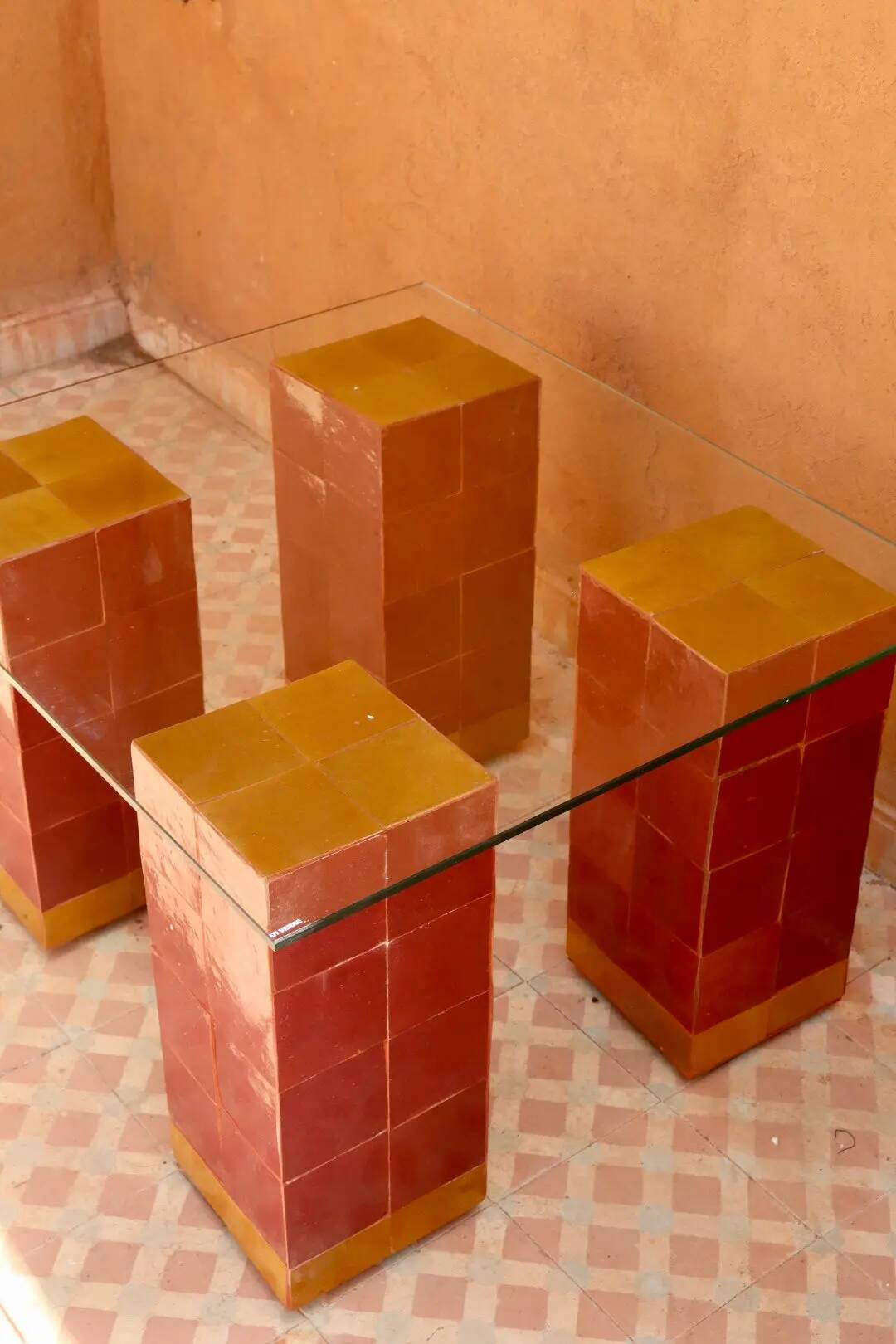 Modern coffee table in burgundy zellige with a tempered glass top.