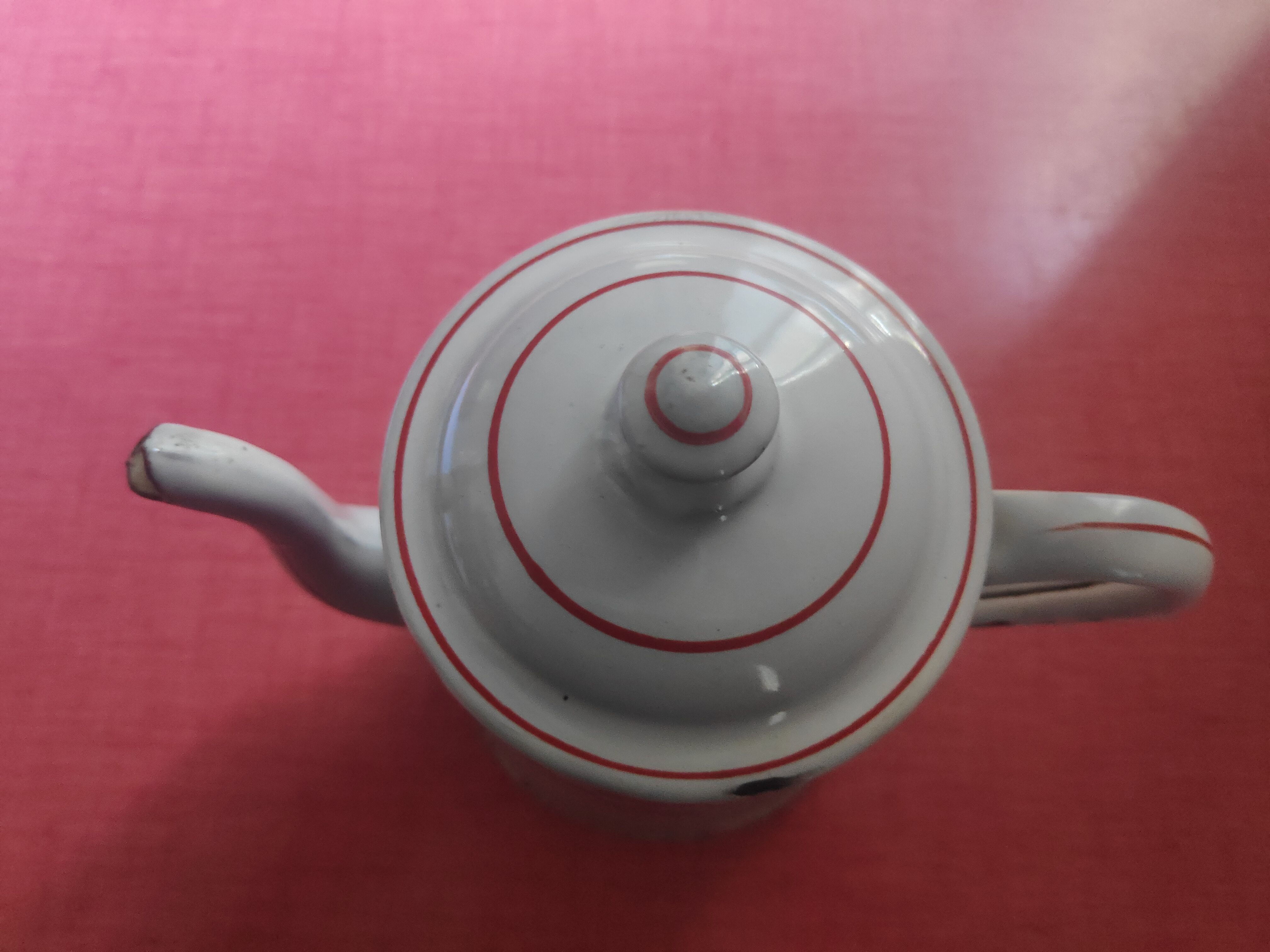 White enamelled sheet metal coffee maker with red and blue patterns