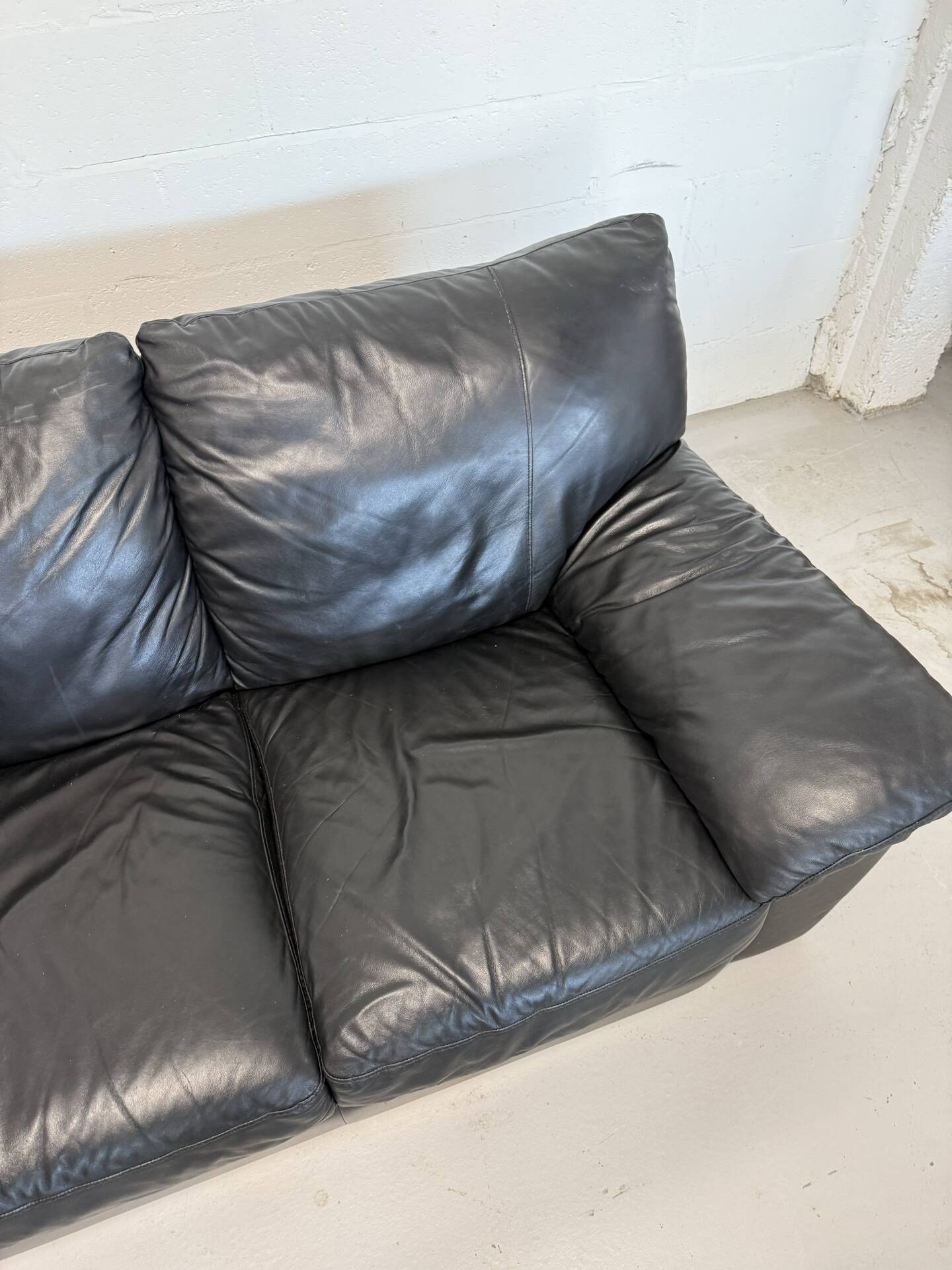 Two-seater black leather sofa — postmodern design