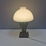 Small stylish table lamp with perforations and milky white opal glass shade