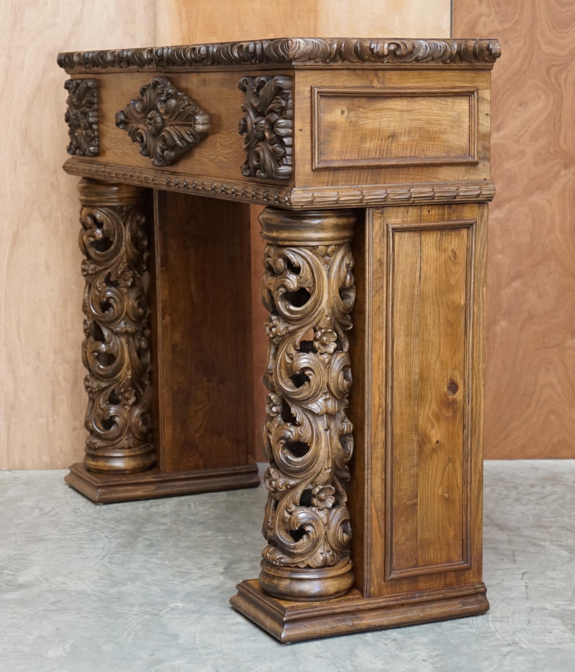 Antique fireplace from around 1880 in solid hand-carved elm with openwork columns.