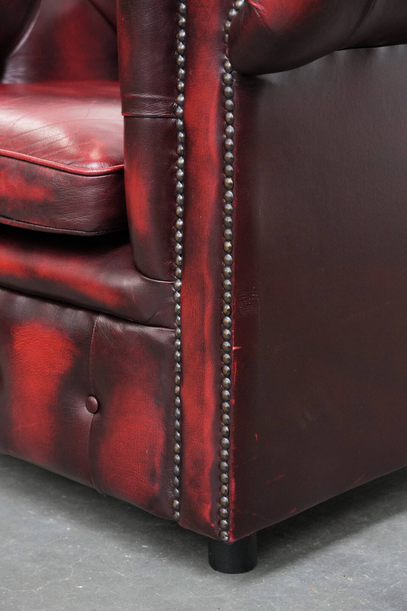 Red English cowhide Chesterfield armchair finished with decorative nails