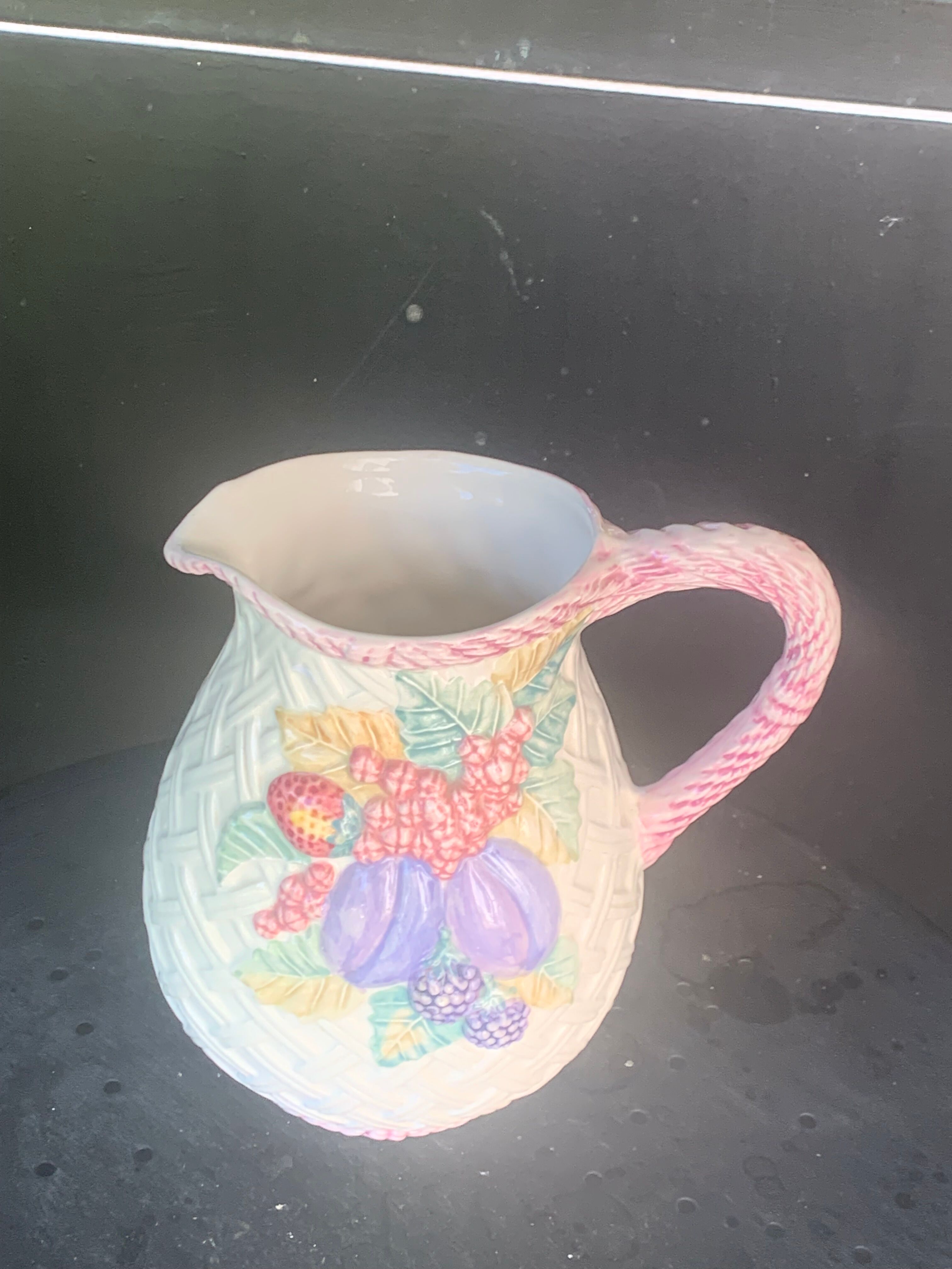 Glazed ceramic slip jug with vintage basket and fruit motif