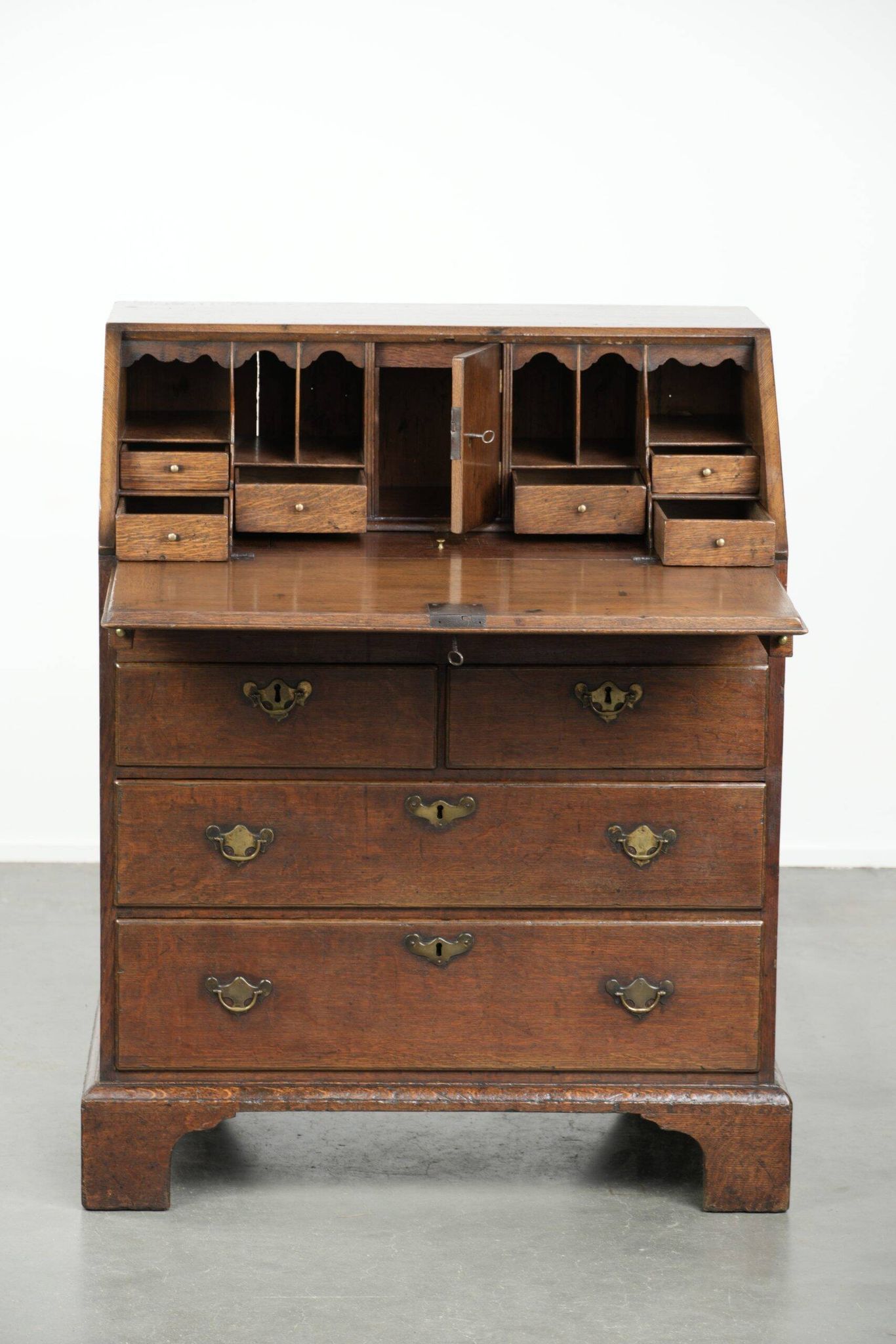Antique English oak secretary from the 18th century with a stepped interior