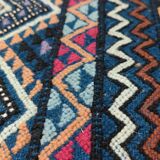 Blue carpet with multicolored patterns woven hands in natural wool