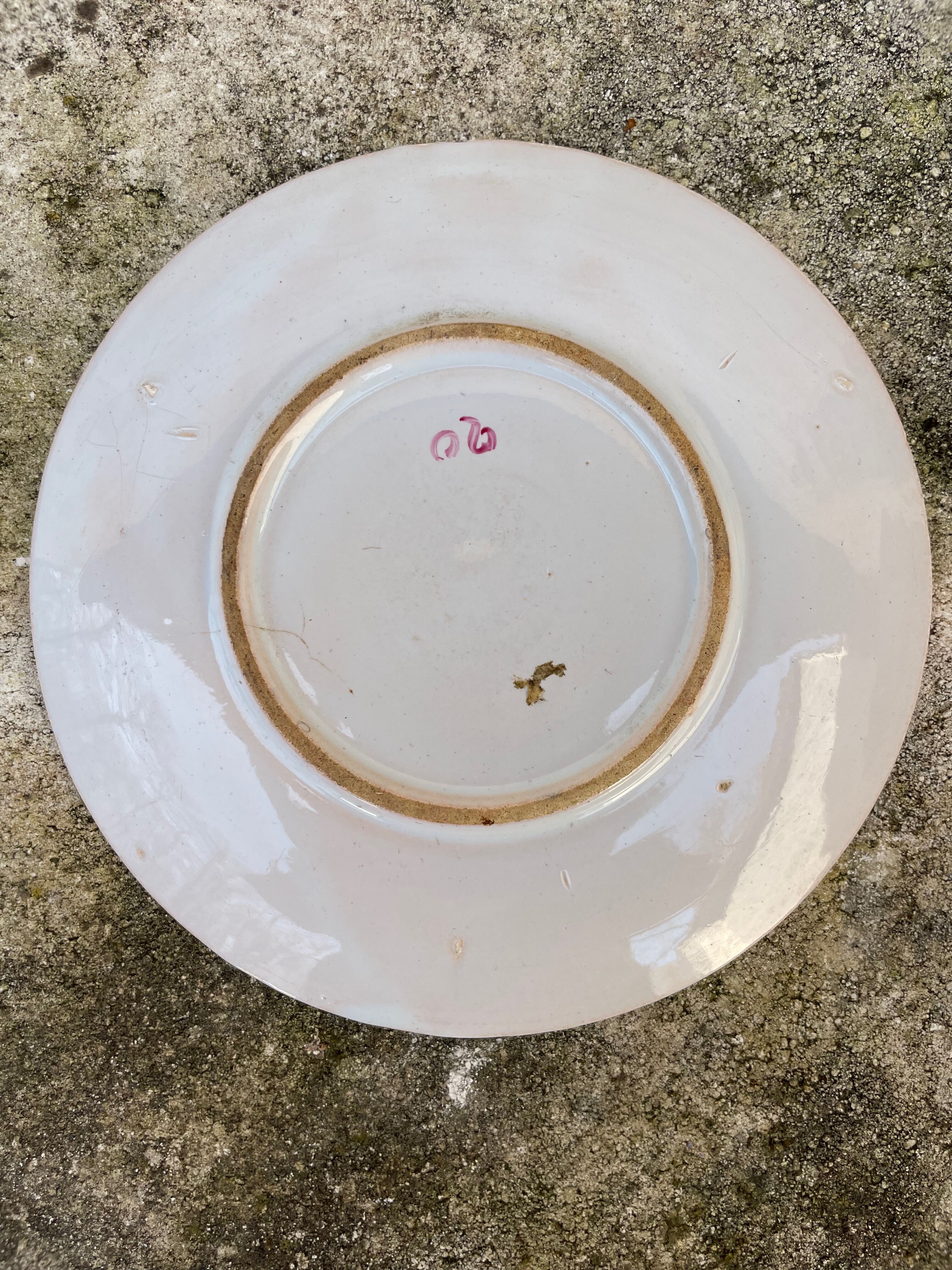 Antique plate with a flower and rooster pattern.