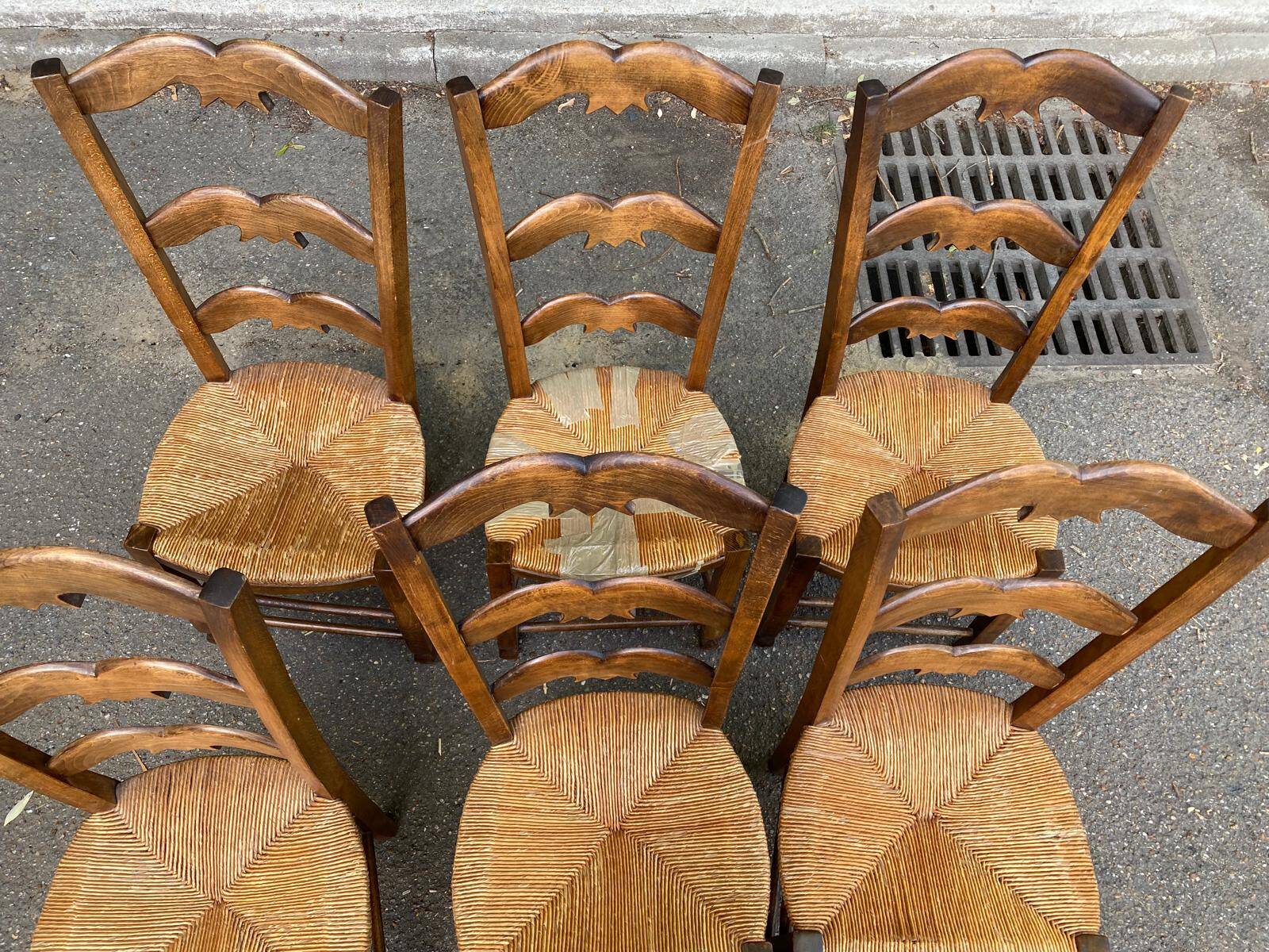 6 solid wood chairs with straw seats and butterfly carved backs.