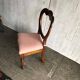 Fauteuil ancien en tissu rose et bois, dossier ajouré en cœur, pieds tournés