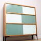 A vintage mid-century 3 tiered bookcase with glass sliding doors
