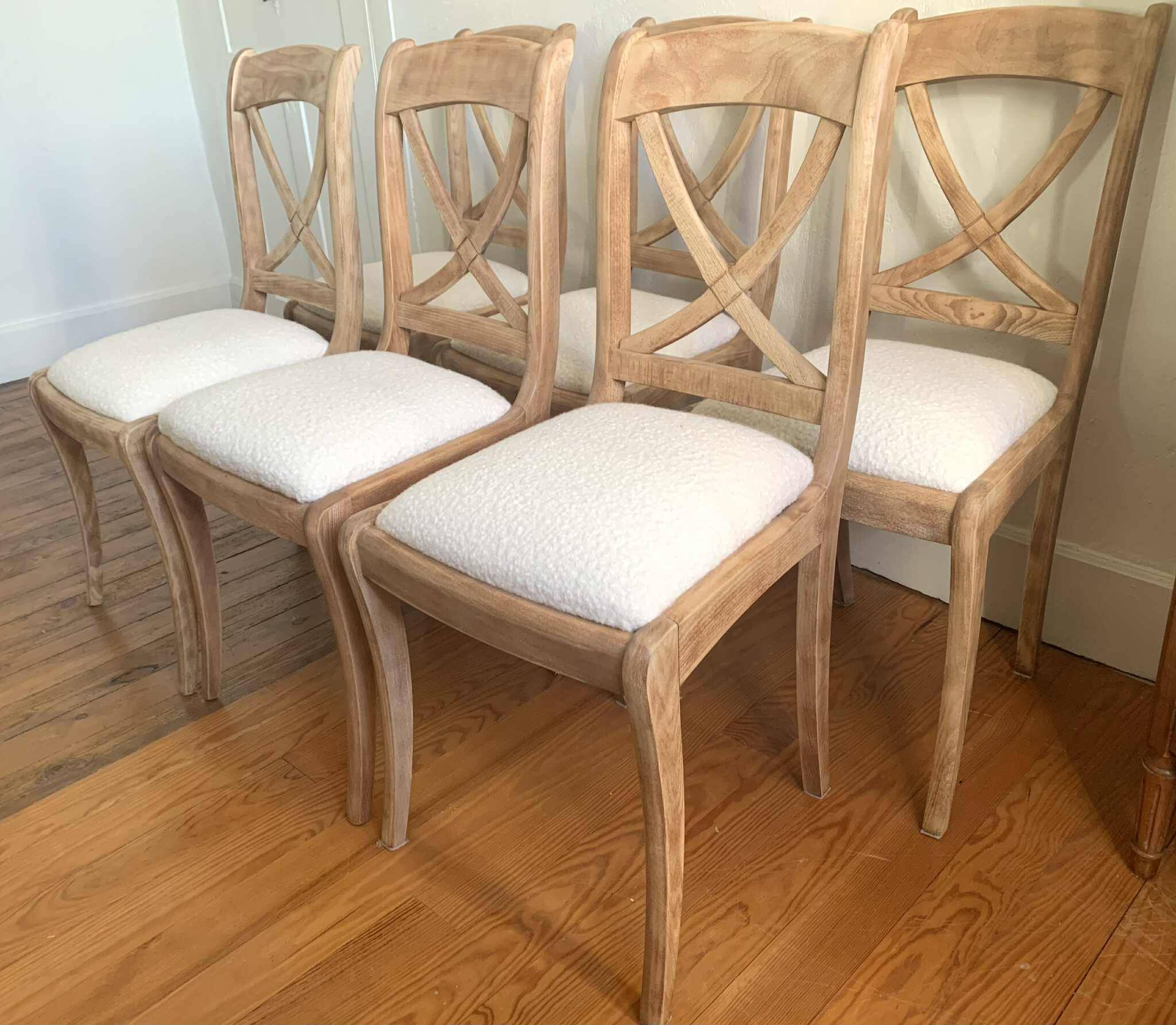 Set of 6 cross-back chairs in solid wood, with white boucle seats.