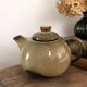 Vintage ceramic teapot with a flame design.