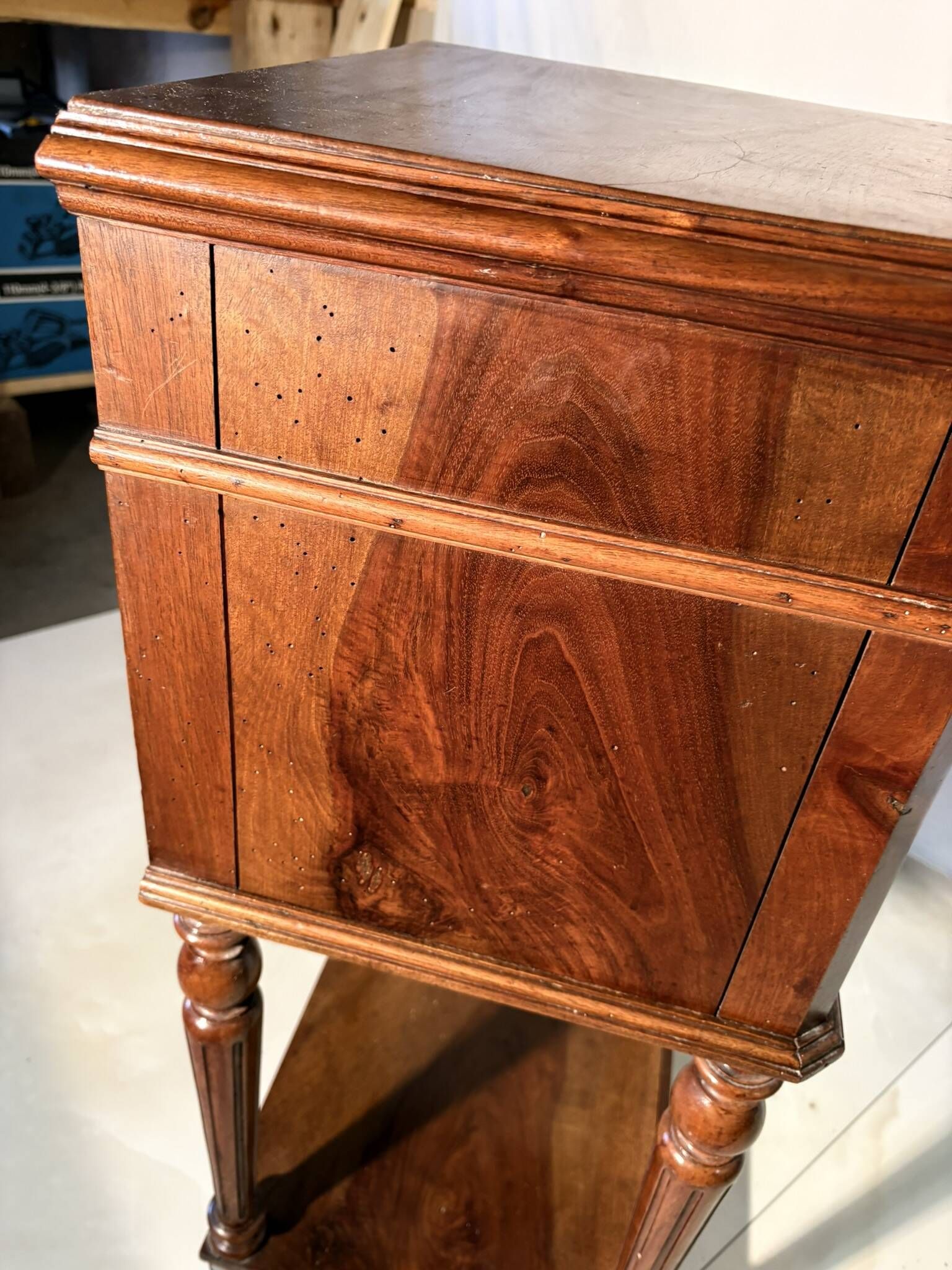 Antique wooden bedside table with turned legs.