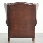 Fauteuil à oreilles en cuir de vache confortable de style anglais avec un look intemporel.