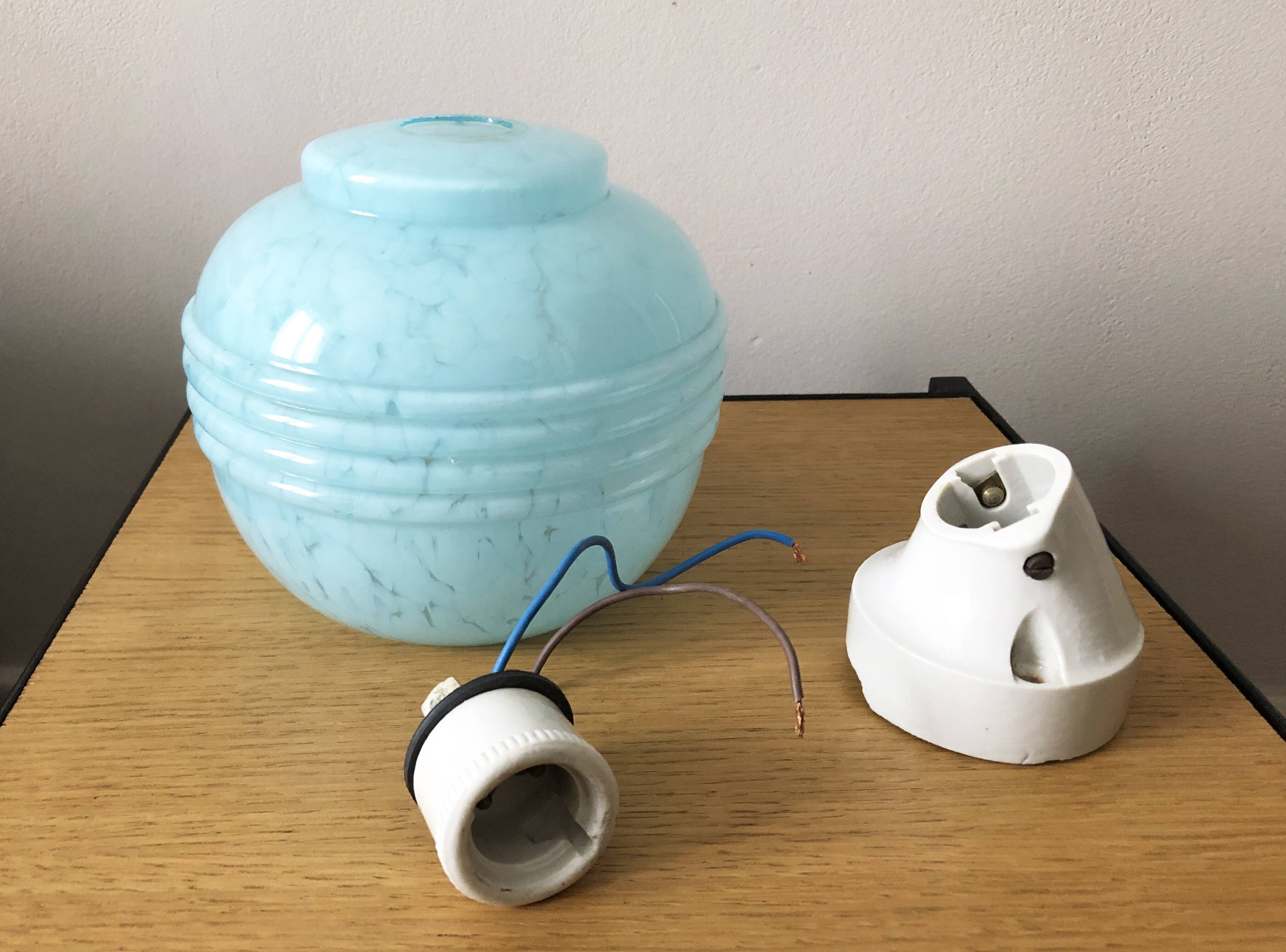 Wall light in ceramic with a light blue glass globe.
