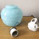Wall light in ceramic with a light blue glass globe.