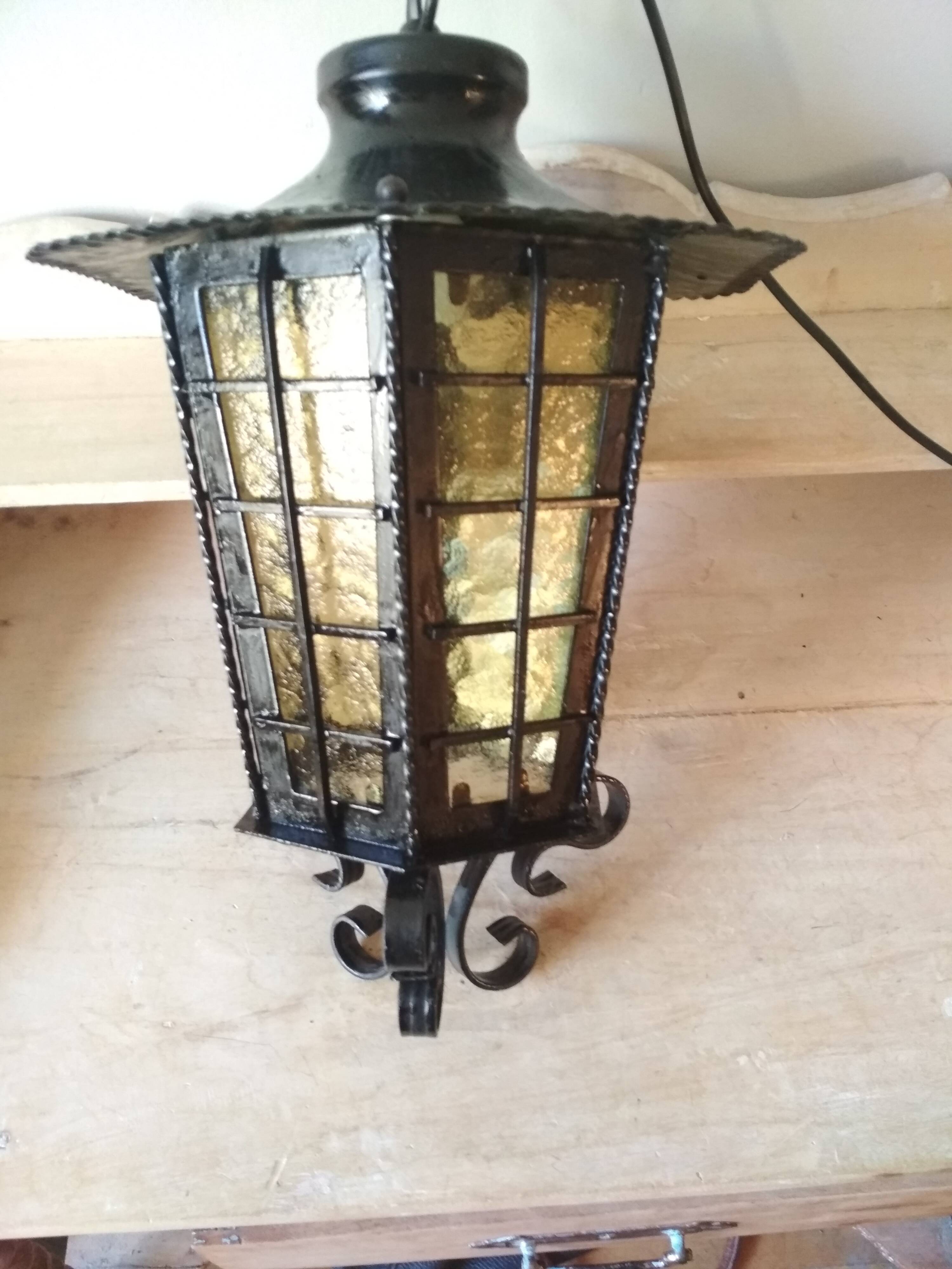Large hanging lantern in wrought iron and opaque yellow-orange windows