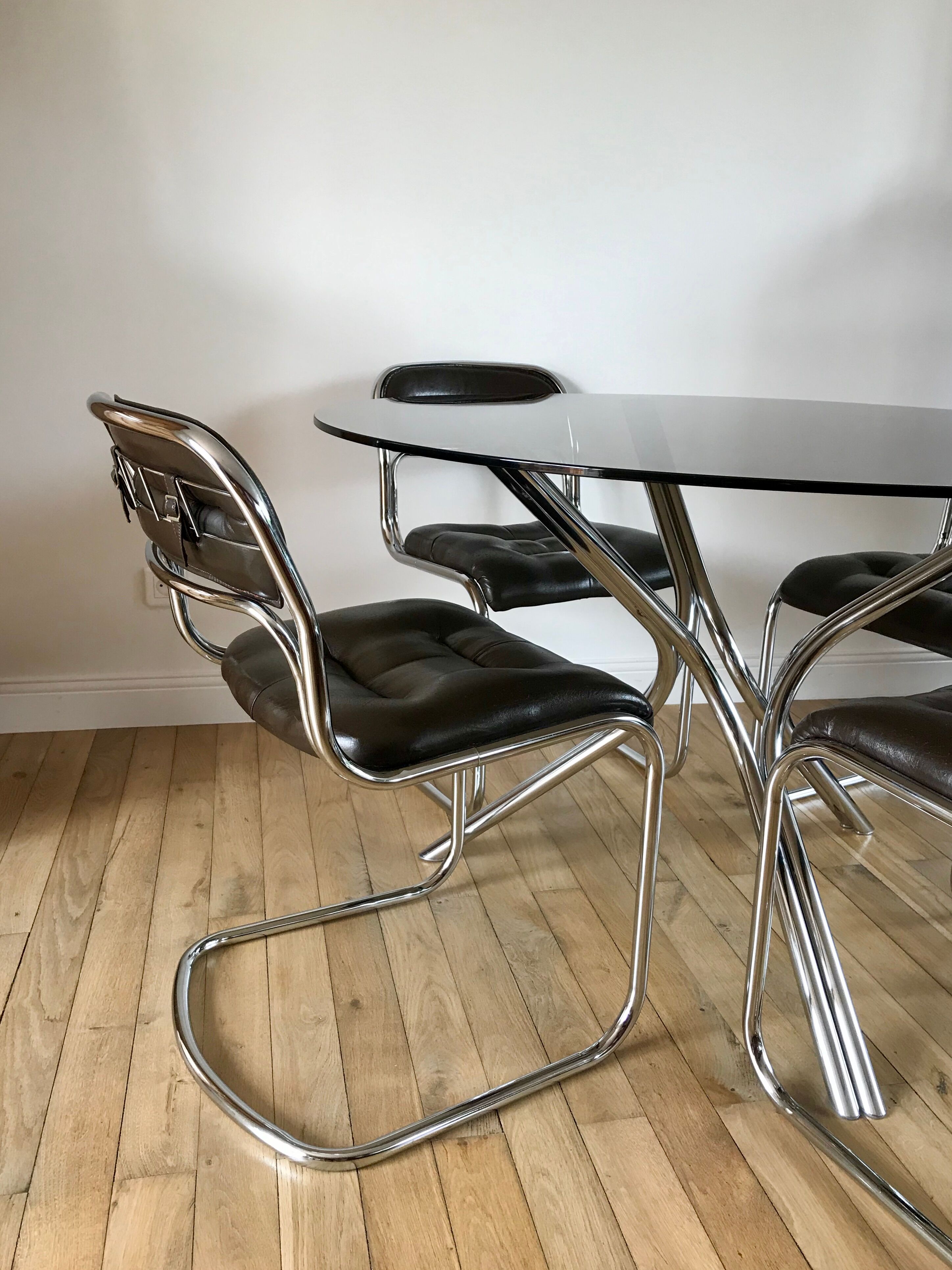 Set consisting of a table in chrome and smoked glass and its 4 tubular chairs in chrome and skaï a