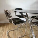ensemble composé d'une table en chrome et verre fumé et ses 4 chaises tubulaires en chrome et skaï a