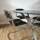 Set consisting of a table in chrome and smoked glass and its 4 tubular chairs in chrome and skaï a
