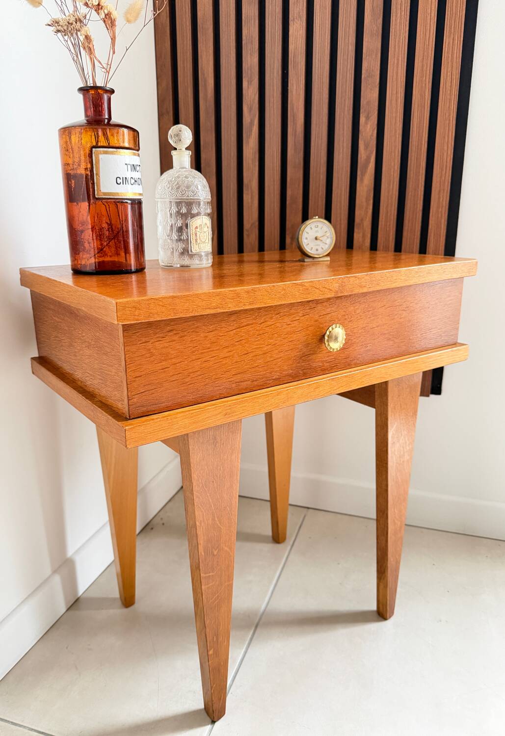 Vintage bedside table with tapered legs.