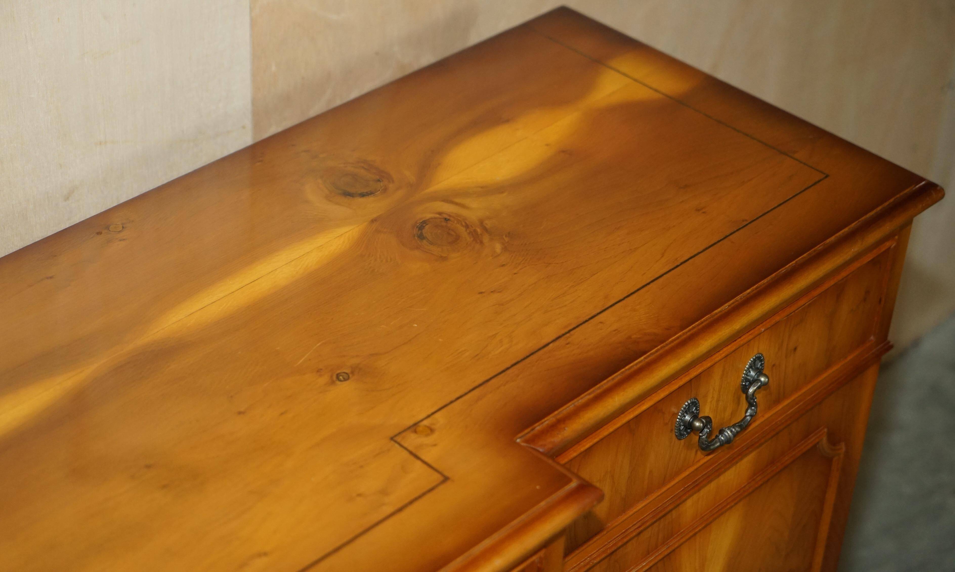 Vintage buffet made of mottled yew wood with three doors and four drawers.