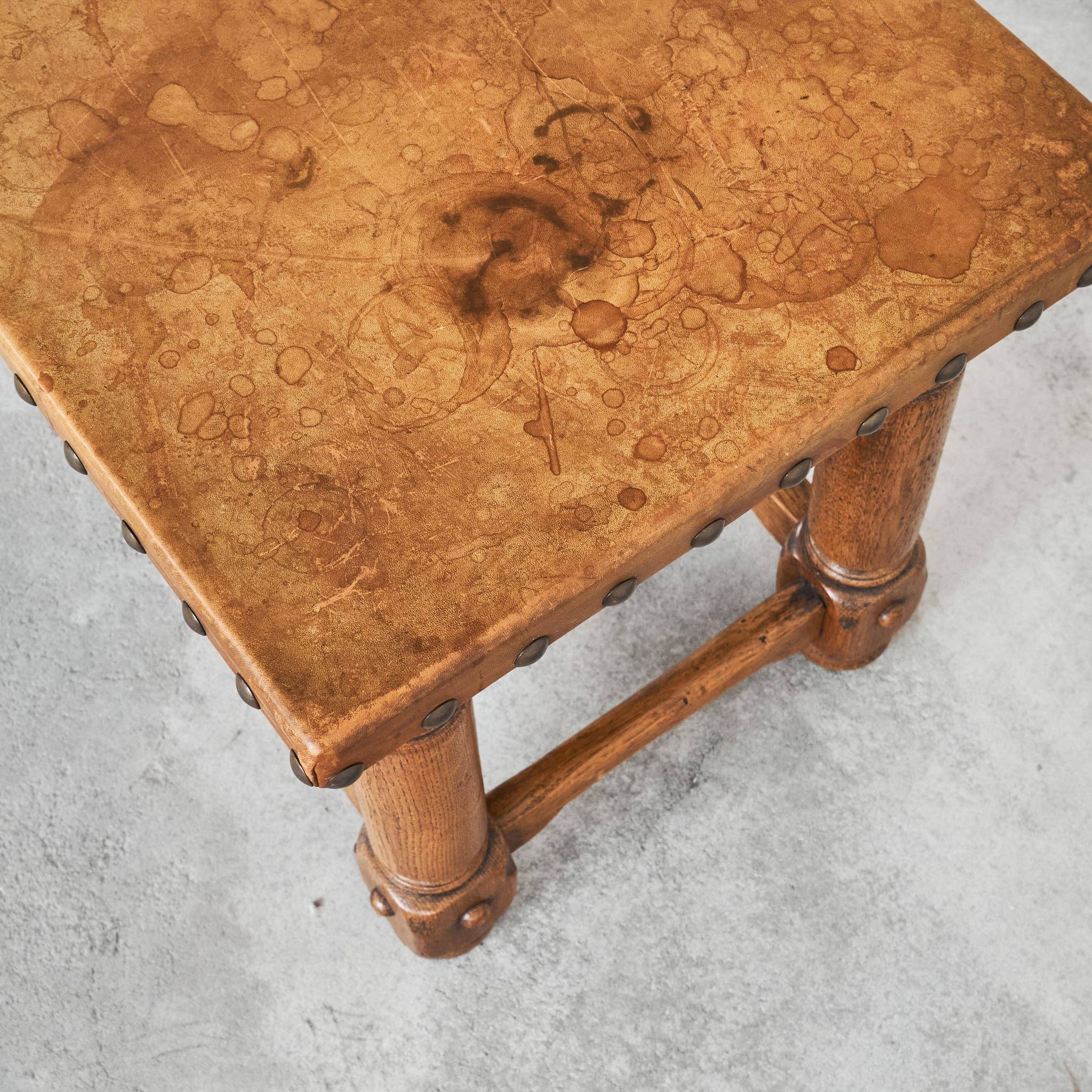 Brutalist coffee table in solid oak, metal, and patinated leather, 1940s.