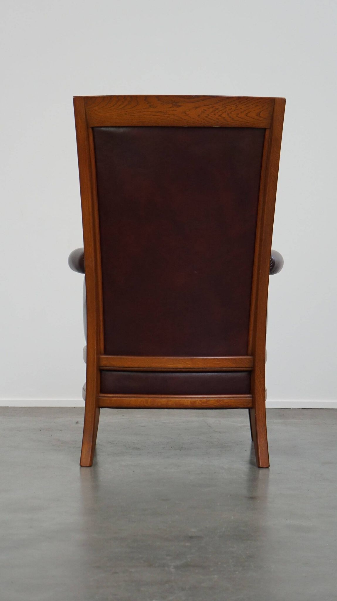 Very comfortable classic cowhide armchair with a high back in a mild Art Deco style