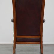 Very comfortable classic cowhide armchair with a high back in a mild Art Deco style