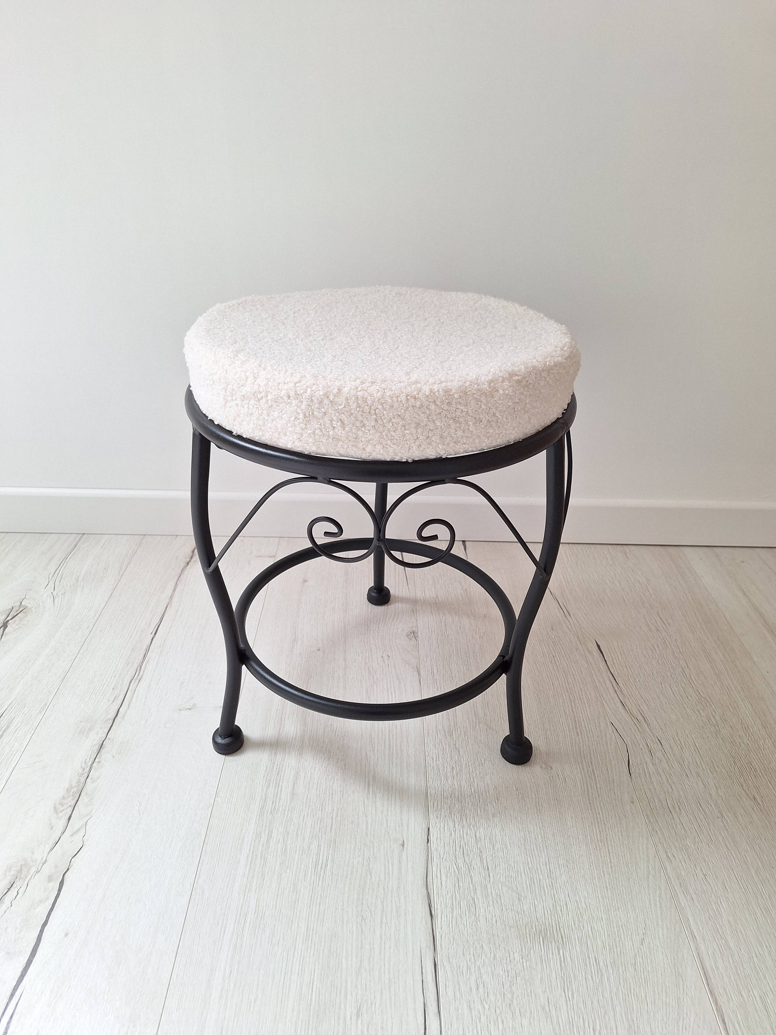 Black iron stool/pouf with its boucle fabric cushion.